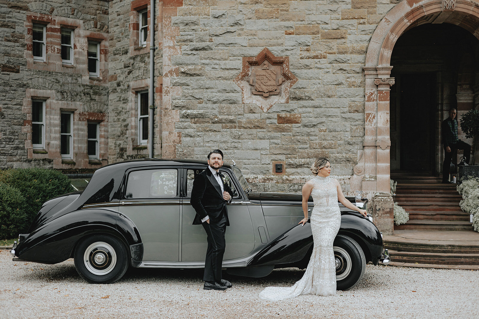 Bride and groom posing in front of a car at The Castle Leslie Ireland  Wedding